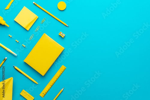 Fotomural Top view photo of yellow stationery over turquoise blue background with copy space