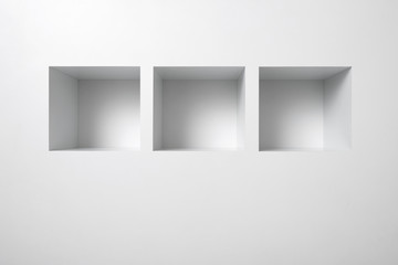 Empty shelf for exhibit in white wall.