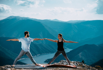 Couple of muscular man and woman meditating in yoga pose