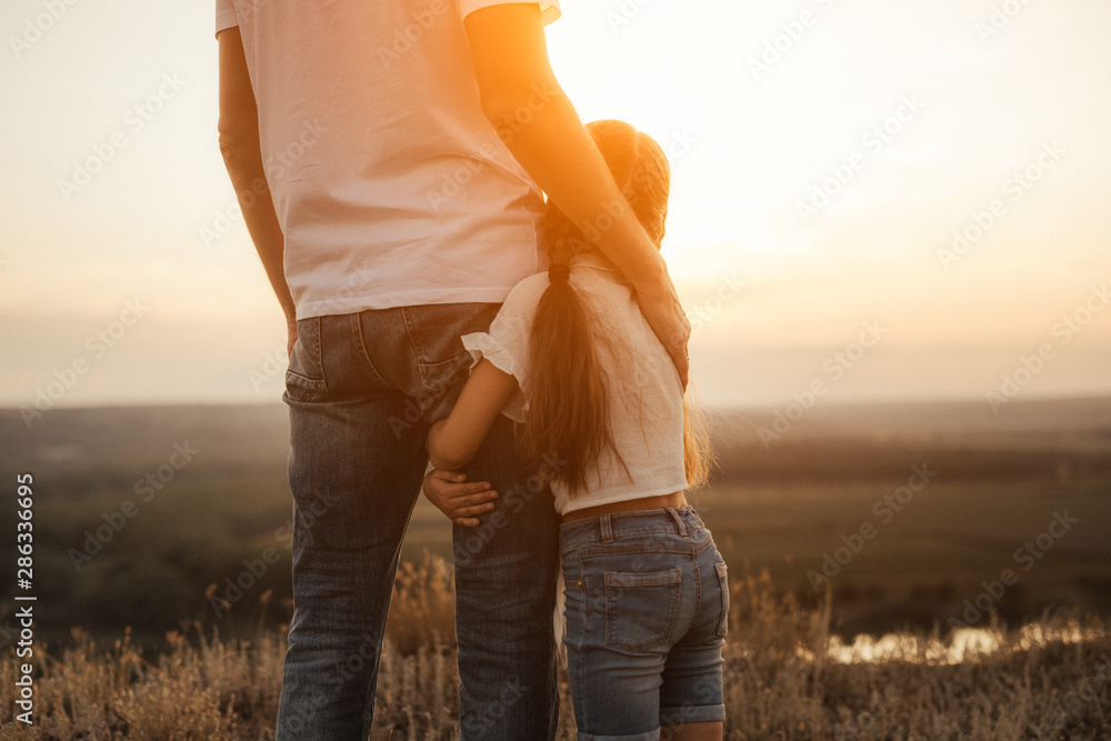 Happy father and daughter hugging while standing at countryside - obrazy, fototapety, plakaty 