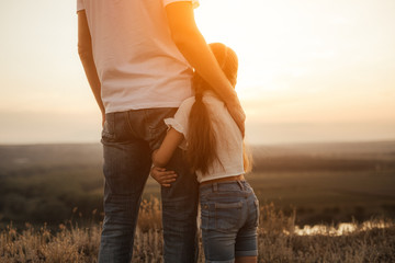 happy father and daughter hugging while standing at countryside