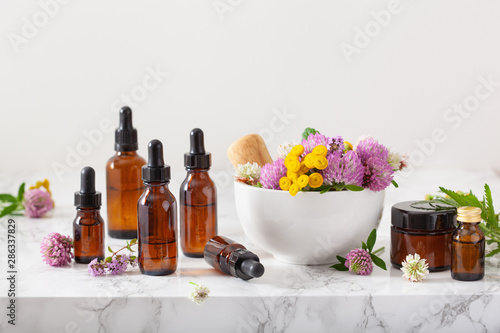 Fotografía medical flowers herbs in mortar essential oils in bottles