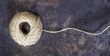 Jute twine roll on a grunge rusty metal background, top view, web banner with copy space