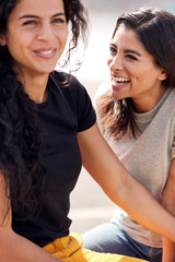 Two Female Friends Meeting In Urban Skate Park