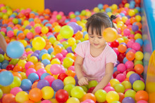 Smiling Baby Playing In The Balls Pool. Cute And Happy Girl. Picture For Developmental In Children Concept.