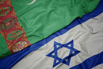waving colorful flag of israel and national flag of turkmenistan.