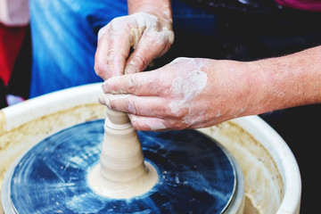 Potter's hands skillfully form a jug on a potter's wheel_