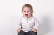 © Dmitry - European baby or toddler sits and smiles in front of a white background