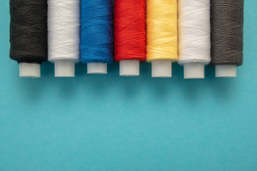 Set of sewing threads beautiful color (blue,yellow, green, white, black) on blue background