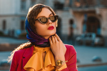 Outdoor Close Up Fashion Portrait Of Elegant Lady Wearing Trendy Colorful Head Scarf, Black Cat Eye Sunglasses, Golden Wrist Watch, Posing In Street Of City. Copy, Empty Space For Text