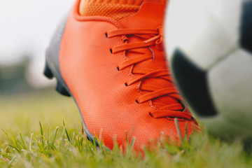 Kicking the soccer ball; close-up and low angle view