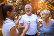 © Mediteraneo - Senior man and woman and young female instructor workout on fresh air, they rest and drink water. Outdoor activities, healthy lifestyle, strong bodies, fit figures.