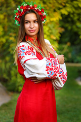 portrait of young woman in autumn park in national Ukrainian wear red Embroidered shirt