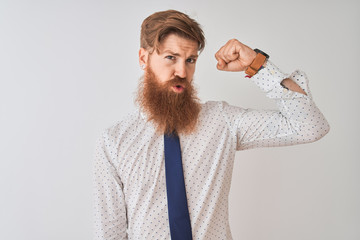 Wall Mural - Young redhead irish businessman standing over isolated white background Strong person showing arm muscle, confident and proud of power