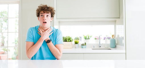 Wide shot of young handsome man at home shouting and suffocate because painful strangle. Health problem. Asphyxiate and suicide concept.