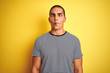 © Krakenimages.com - Young handsome man wearing striped t-shirt over yellow isolated background making fish face with lips, crazy and comical gesture. Funny expression.