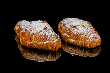 Wall Mural - Almond croissant on black glass with reflection