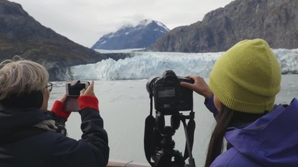 Wall Mural - Alaska Glacier Bay Tourists looking at landscape using binoculars and taking pictures on cruise ship. People on vacation travel looking at Margerie Glacier and wildlife cruising famous destination.