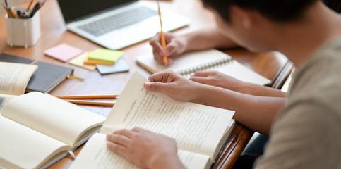 Hard-working college man reading books during the exam period