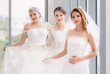 © Bangkok Click Studio - Brides standing and holding their  wedding dress..