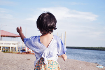 Asian little children are walking by the sea