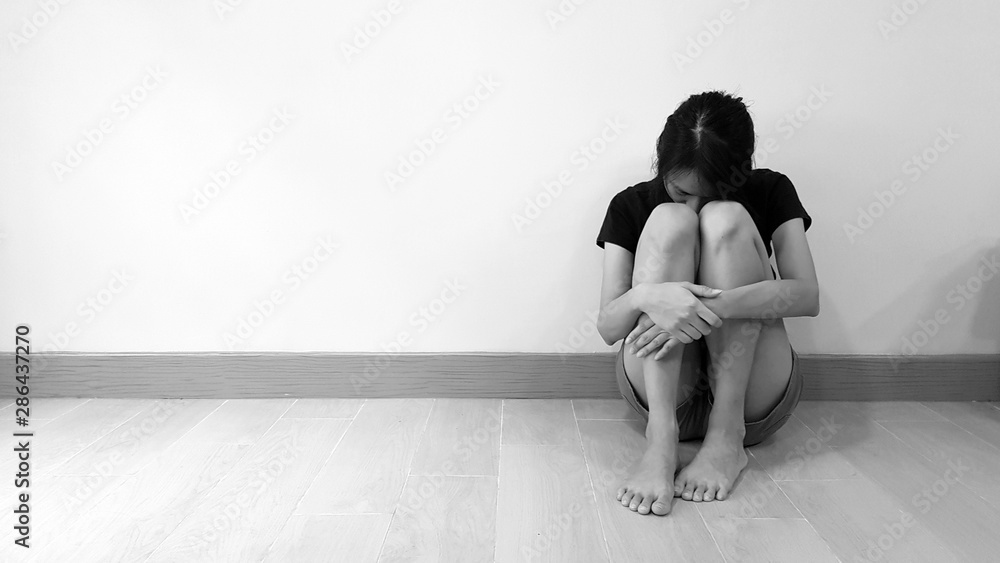 Sad woman hug her knee and cry. Patient has depression mood, low self esteem, and suicidal attempt idea from major depressive disorder (MDD). Mental health care and medical problem concept - obrazy, fototapety, plakaty 