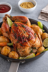 Wall Mural - Roast chicken whole. Served on a plate with vegetables and baked potatoes. Front view.