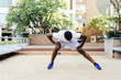 © twinsterphoto - Athletic African American man in blue sneakers doing stretching exercise while training in park on sunny day