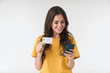 © Drobot Dean - Image of gorgeous brunette woman wearing casual clothes holding credit card and cellphone