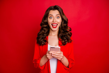 Sticker - Portreait of cheerful lady with bright lips stick screaming wow omg reading news on her cell phone isolated over red background