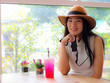 © Phuttharak - Beautiful Asian tourist  weating hat sitting in cafe with camera in her hand