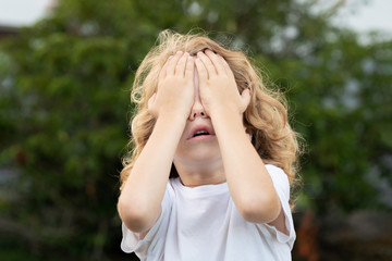 Canvas Print - Blond child covering his eyes