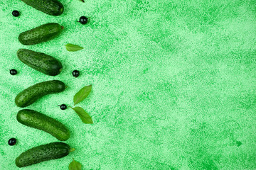 Wall Mural - Fresh cucumbers on a green background. View from above