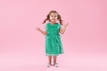 Funny Little Kid, Toddler Girl In Fashionable Green Dress Isolated On Pink Background