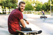 © Drobot Dean - Attractive young man sitting at the skate park