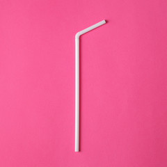 Two white plastic straws on pink background