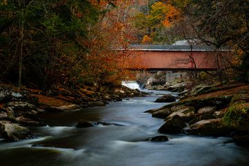 Wall Mural - Rustic Red Covered Bridge Over Rushing Stream in Peak Autumn / Fall Season - McConnells Mill State Park - Pennsylvania