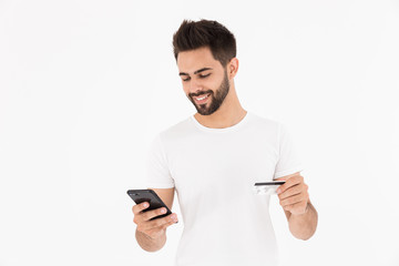 Sticker - Image of handsome pleased man holding credit card and using cellphone