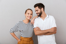 Smiling Happy Young Loving Couple Friends Man And Woman Posing Indoors Isolated Over Grey Background.
