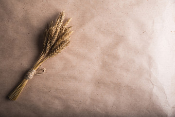 Wall Mural - bunch of wheat ears on the background of Kraft paper