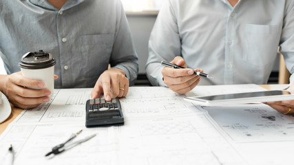 Wall Mural - Confident engineer team working with Blue Print with architect equipment discussing and Planning work flow construction project. with partner at the table in office work site.