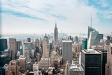 Fototapeta  - New York City Manhattan, NYC/ USA - 08 21 2017: Top of the Rock panorama view over skyline from Rockefeller center to NYC and the Empire State building on a light cloudy sunny day with blue sky