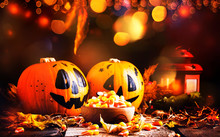 Halloween Festive Composition With Sweet Corn In Bowl And Smiling Pumpkins Guards, Lantern, Straw And Fallen Leaves On Dark Wooden Background, Rustic Style, Selective Focus