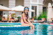 © travnikovstudio - Adorable little girl swimming at outdoor swimming pool