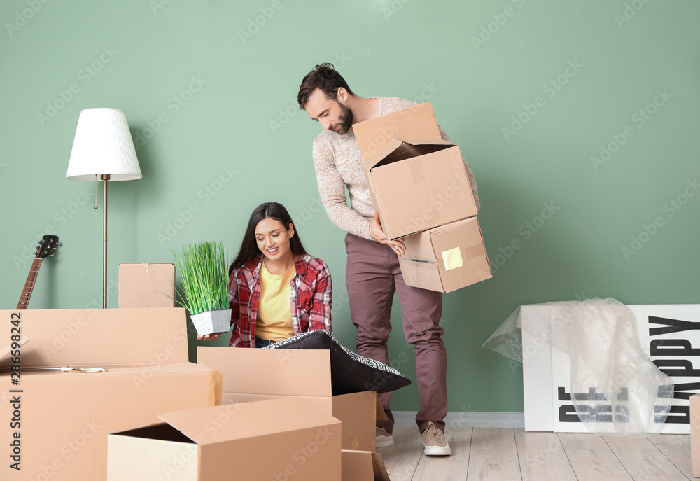 Young couple unpacking things after moving into new house