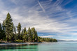 USA, California, El Dorado County, D.L. Bliss State Park. The shoreline and green waters of Lake Tahoe on a day with whispy clouds.