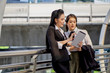 © PANYA - Both females business partnership In Stylish Office Clothes black and white concept they talking about something in the tablet