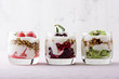 healthy dessert with whipped cottage cheese, granola, strawberries, cherries and kiwi on pink background