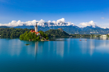 Wall Mural - Bled, Slovenia - Lake Bled (Blejsko Jezero) with the Pilgrimage Church of the Assumption of Maria on a small island and Bled Castle and Julian Alps at backgroud at summer time with clear blue sky