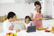© xreflex - Happy Asian family make a cooking. Father, Mother and Daughter are preparing fruit orange and see Digital tablet in the kitchen at home. Healthy food concept and happy holidays